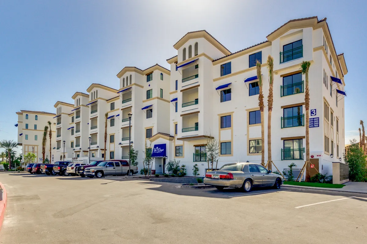 A welcoming exterior showing modern architecture, tall palm trees, expansive windows, and prominent entrance signage. The area is landscaped for outdoor enjoyment, with plenty of space for casual gatherings or strolls.
